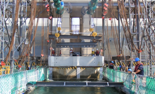 鋼絲繩電動(dòng)葫蘆吊裝，倒鏈微調(diào)，確保導(dǎo)流墩預(yù)制塊精準(zhǔn)安裝